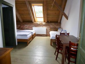 a room with two beds and a table and chairs at U Devíti vidlí in Žlutice