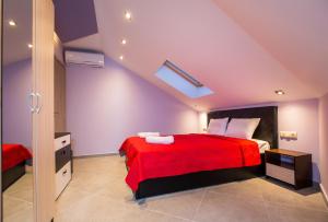 a bedroom with a bed with a red blanket at Dorothea Suite in Potos