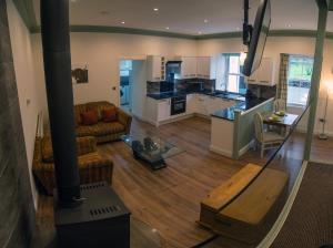een grote woonkamer met een bank en een keuken bij Owls Nest in Edinbain