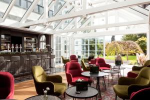 キッツビュールにあるERIKA Boutiquehotel Kitzbühelの赤い椅子とバーのあるロビー