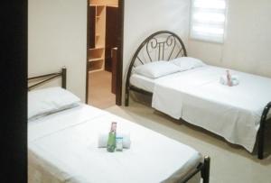 two beds in a room with two candles on them at Skyleigh Apartelle by RedDoorz in Iloilo City