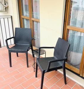 Appartamento Giallo في بسكيرا ديل غاردا: ثلاثة كراسي سوداء جالسة على الشرفة