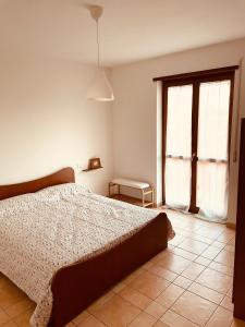 Appartamento Giallo في بسكيرا ديل غاردا: غرفة نوم بيضاء بها سرير ونافذة
