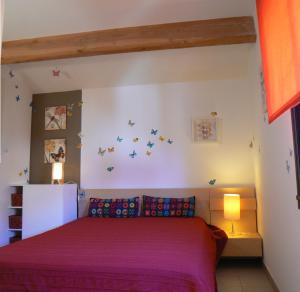 ein Schlafzimmer mit einem Bett mit lila Laken und Schmetterlingen an der Wand in der Unterkunft Bel Air -les Restanques in La Ciotat