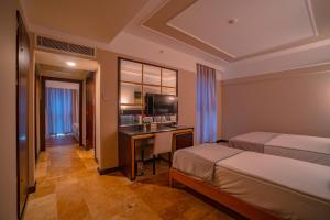 a hotel room with two beds and a desk at Royal Atlantis Spa & Resort in Side +30 photos