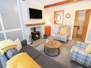 a living room with a couch and a fireplace at Feathers Cottage in Haworth