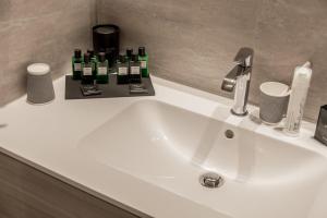 a white bathroom sink with green bottles on it at EUROPA Hotel in Vasto
