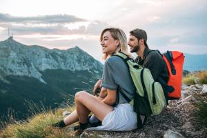 a man and a woman sitting on top of a mountain at ALM SEASONS Premium Chalet & Studios in Saalbach-Hinterglemm