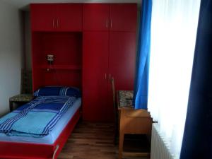Schlafzimmer mit roten Schränken und einem Bett in der Unterkunft Backpackers Gasthaus Post in Willisau