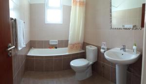 een badkamer met een toilet, een bad en een wastafel bij The well-equipped luxury apartment Paphos Riviera in Paphos City