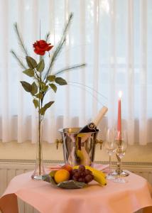 una mesa con un jarrón con una flor y una vela en Hotel Ilmenautal inklusive THERMEplus, en Bad Bevensen