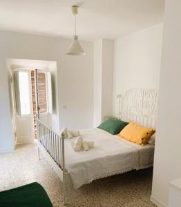 a bedroom with a white bed with two stuffed animals on it at Casetta romantica a Collepardo in Collepardo