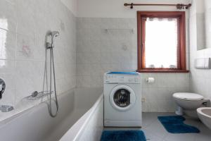 La salle de bains est pourvue d'une baignoire et d'un lave-linge. dans l'établissement Appartamento Campacc, à Livigno