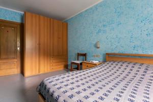 - une chambre bleue avec un lit et une armoire en bois dans l'établissement Appartamento Campacc, à Livigno