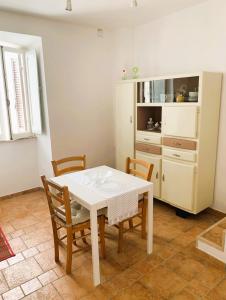 uma sala de jantar com uma mesa branca e cadeiras em Casetta romantica a Collepardo em Collepardo
