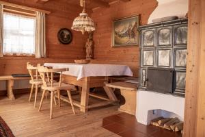 a dining room with a table and a stove at Ferienhaus Haus Gilfert in Pill