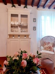 uma sala de estar com uma cabana e uma mesa com rosas em Rustico degli Ulivi em Vallecchia
