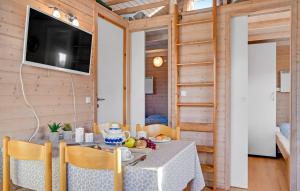 een eetkamer met een tafel en stoelen en een televisie bij Toftum Bjerge Camping & Cottages in Humlum