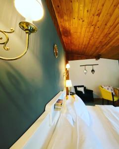 um quarto com uma cama e um candeeiro na parede em Bohemian Chalet em Buşteni