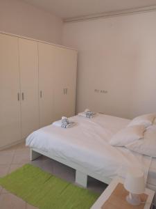 ein Schlafzimmer mit einem großen weißen Bett und einem grünen Teppich in der Unterkunft Apartment Marta in Rab