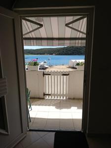 eine offene Tür zu einem Balkon mit einem Boot im Wasser in der Unterkunft Apartment Marta in Rab