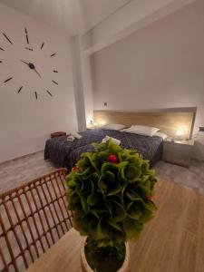 a large green plant in a room with a clock on the wall at Diana in Ermoupoli