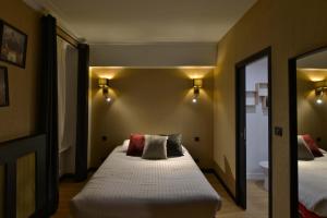 una camera da letto con un letto grande e uno specchio di Hôtel Le Tiburon a Cherbourg en Cotentin