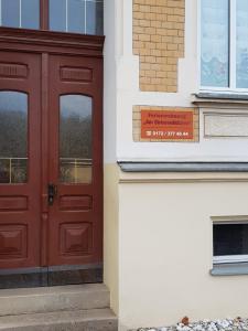 una puerta roja en el lateral de un edificio en Ferienwohnung am Birkenwäldchen en Plauen