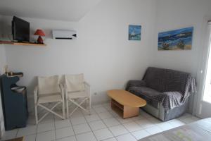 sala de estar con sofá y silla en Belle villa 5 couchages terrasse Sud parking dans résidence sécurisée piscine commune 400m de la mer LRJP102, en Portiragnes