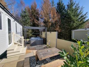 a backyard with a deck with a picnic table and a trailer at Cheviot Pines Hot tub in Swarland