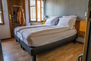 - duże łóżko z białymi poduszkami w pokoju w obiekcie Hôtel Au Vieux Moulin w mieście Lapoutroie