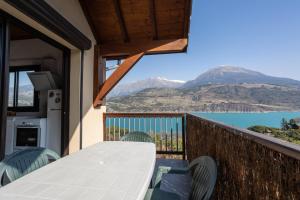 a balcony with a table and chairs and a view of a lake at Le Bleuet du Lac in Savines