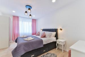 um quarto com uma cama grande e cortinas cor-de-rosa em Zara Lumina Apartment em Zadar