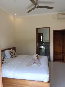 um quarto com uma cama com um bicho de peluche em Diary home stay em Ubud