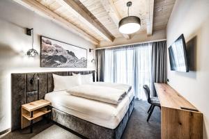 um quarto de hotel com uma cama e uma secretária em Sonnalp Residences em Sölden
