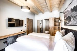 1 dormitorio con 2 camas y TV en Sonnalp Residences en Sölden