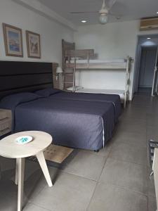 Schlafzimmer mit einem blauen Bett und einem Tisch in der Unterkunft Dionysos Central in Paphos City