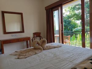 a bedroom with a bed with a towel on it at Diary home stay in Ubud