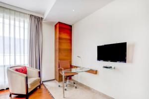 a hotel room with a desk and a tv on a wall at Hotel Elements in Amrāvati