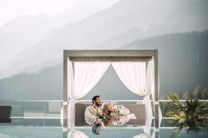 a man sitting in a bed holding a baby at Stock Resort in Finkenberg