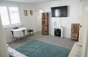 a living room with a table and a tv at Sunnyside - Back Road East St Ives - Sleeps 4 in St Ives