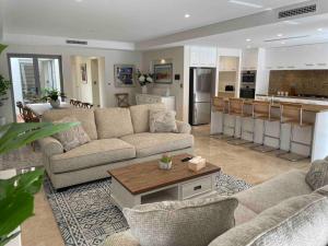 a living room with two couches and a kitchen at Canal Vista in Mandurah