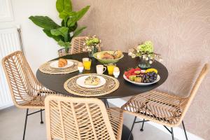 une table noire avec de la nourriture et des chaises dans l'établissement StayatSas Tiny House Sam in de bossen op de Veluwe!, à Epe