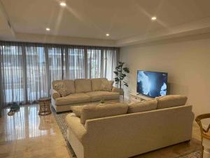 sala de estar con 2 sofás y TV de pantalla plana en Canal Vista en Mandurah