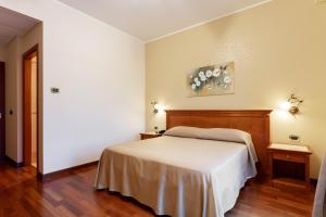 1 Schlafzimmer mit einem weißen Bett und 2 Tischen in der Unterkunft Domus Hotel in Bagnoli del Trigno