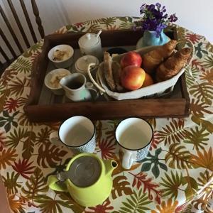 uma mesa com uma bandeja de comida e chávenas de café em Mas de Bruget em Catus