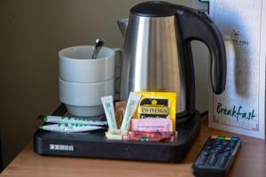 eine Kaffeemaschine, eine Tasse und eine Fernbedienung in der Unterkunft The Waverley Hotel in Callander