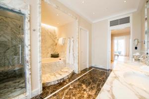 a bath room with a bath tub and a mirror at Palazzo Parigi Hotel & Grand Spa - LHW in Milan
