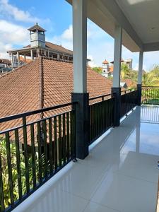 a balcony with a black railing and a clock tower at Diary home stay in Ubud