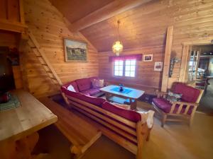 una sala de estar con sofá y mesa en una cabaña de madera en Hakkesetstølen Fjellstugu, en Geilo